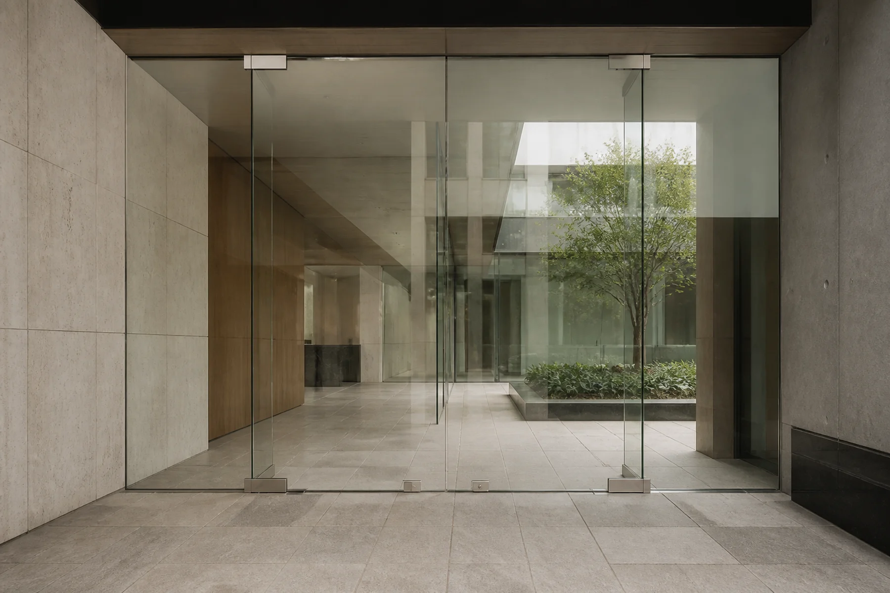 Representative frameless glass entrance opening onto an interior courtyard